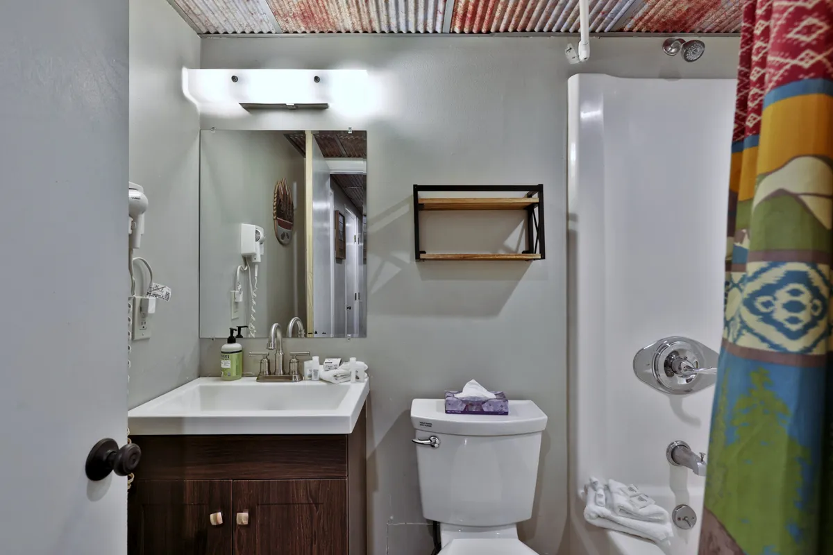 A fresh, functional bathroom featuring a sink, mirror, toilet, and shower. The lighting is bright and the mood is refreshing, ideal for morning routines or winding down at night.