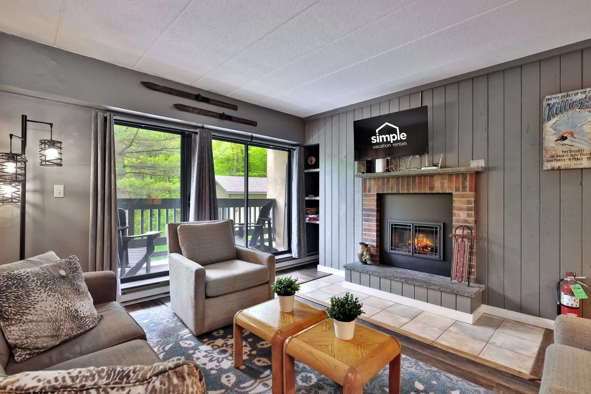 A comfortable living area centered around a fireplace, surrounded by plush seating and large windows that allow in natural light. The setting is cozy and inviting, ideal for ending the night with a book, a drink, or quiet conversation.