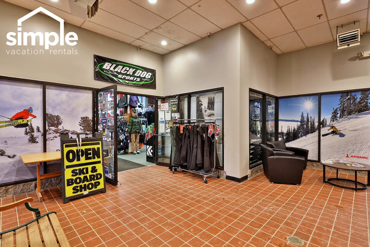 The entrance to a ski and board shop, adorned with an open sign, apparel displays, and murals of snowy mountain landscapes. The vibrant, sporty atmosphere captures the excitement of preparing for winter adventures.